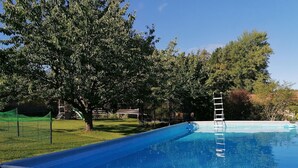 A swimming pool with a ladder, surrounded by trees and a grassy area. - Pet-Friendly Apartment in the Lake District (Fünfseen Ot Petersdorf)