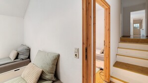 A room with a bed, a wooden door, and a staircase leading to another area. - Apartment 'Albau-wohnung Im Loftstyle' with Wi-Fi (Pforzheim)