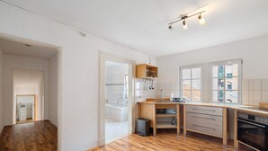 A spacious kitchen with wooden flooring, a built-in oven, and a window providing a view of the outside. - Apartment 'Albau-wohnung Im Loftstyle' with Wi-Fi (Pforzheim)