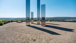 A series of tall, narrow structures with informational plaques, set on a gravel surface with a clear sky and distant hills in the background. - Apartment 'Albau-wohnung Im Loftstyle' with Wi-Fi (Pforzheim)