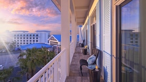 A balcony with a view of a hotel complex and palm trees.