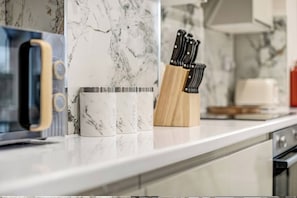 Un plan de travail de cuisine avec un four à micro-ondes, une machine à café et un bloc à couteaux.