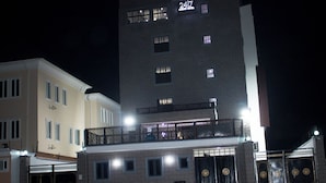 Een hotel met een modern ontwerp, met een groot balkon op de bovenste verdieping en een gelijkvloerse ingang met een bord waarop nummer 2417 staat.