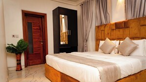 Une chambre à coucher avec un grand lit, une tête de lit en bois et une armoire à miroir.