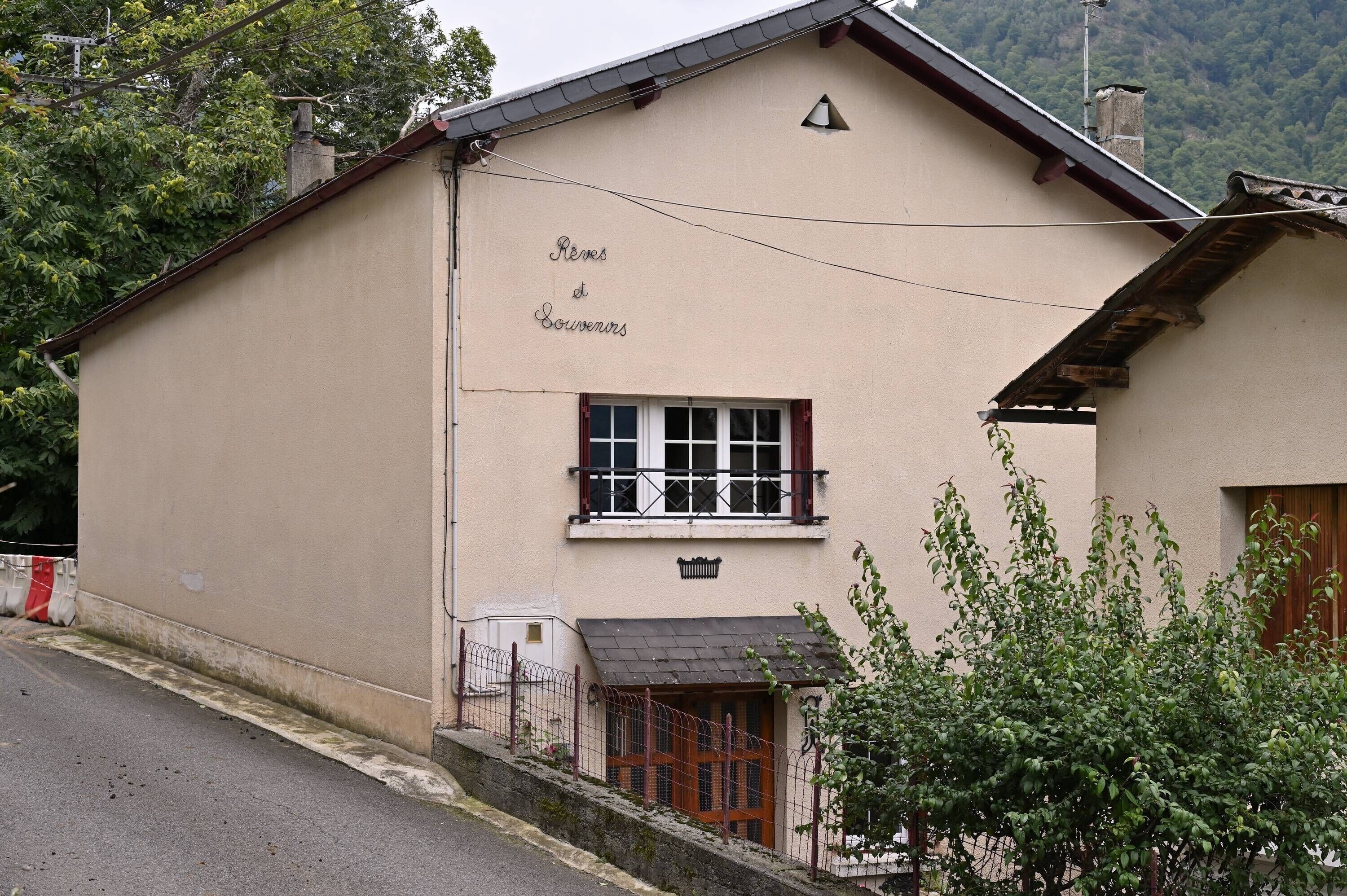 A building with a sign reading 'Reves d'Environs' and a small window with shutters.