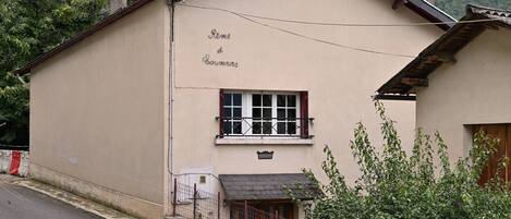 A building with a sign reading 'Reves d'Environs' and a small window with shutters.