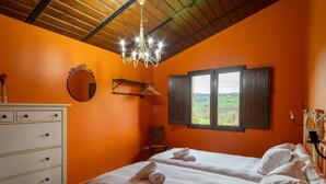 Un dormitorio con dos camas, un tocador, un espejo, una araña y una ventana con vistas.