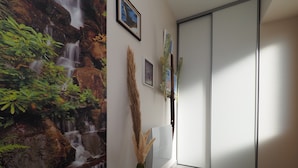 A room with a waterfall mural, a door, and a vase with pampas grass. - Apartment 'La Grange' with Mountain View, Private Garden and Wi-Fi (Cazeaux-de-Larboust)