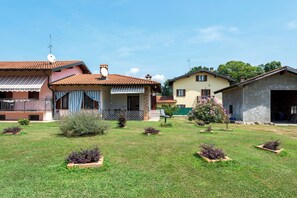 Zona residencial con casas, césped y un árbol pequeño.