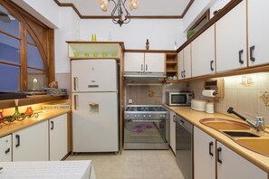 Une cuisine compacte équipée d’un réfrigérateur, d’une cuisinière, d’un four à micro-ondes et d’un évier.