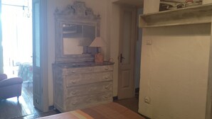 A bedroom with a bed, a dresser, a mirror, and a door leading to another room. - Apartment 'La Vista Sul Castello' with Mountain View, Wi-Fi and Air Conditioning (Compiano)