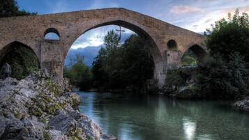 Un ponte in pietra sopra un fiume, con un paesaggio naturale.