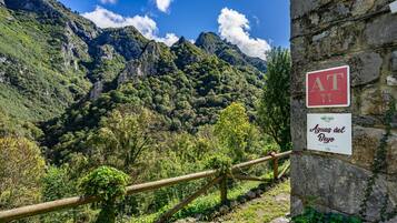 Un muro de piedra con un cartel que dice 'Aguas del Beo' y una valla de madera.