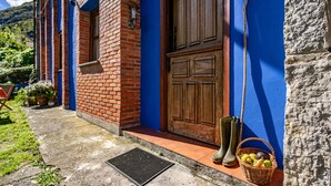 Een gebouw met een blauwe gevel, een houten deur en een bakstenen muur.