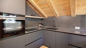A modern kitchen with a built-in oven, a sink, and a coffee maker. - Chalet 'Rain Villa Genf' with Mountain View, Shared Garden and Wi-Fi (Livigno)