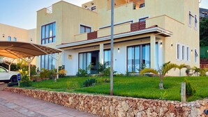 A modern two-story house with a flat roof, large windows, and a covered patio area. - Pazuri at Vipingo  (Kibaoni)