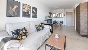 Un salón moderno con sofá, mesa de centro y una obra de arte en la pared.