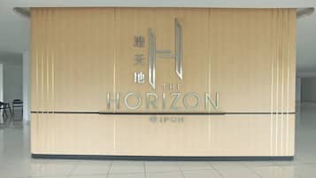A reception desk with a logo and the name 'The Horizon' in English and Chinese.