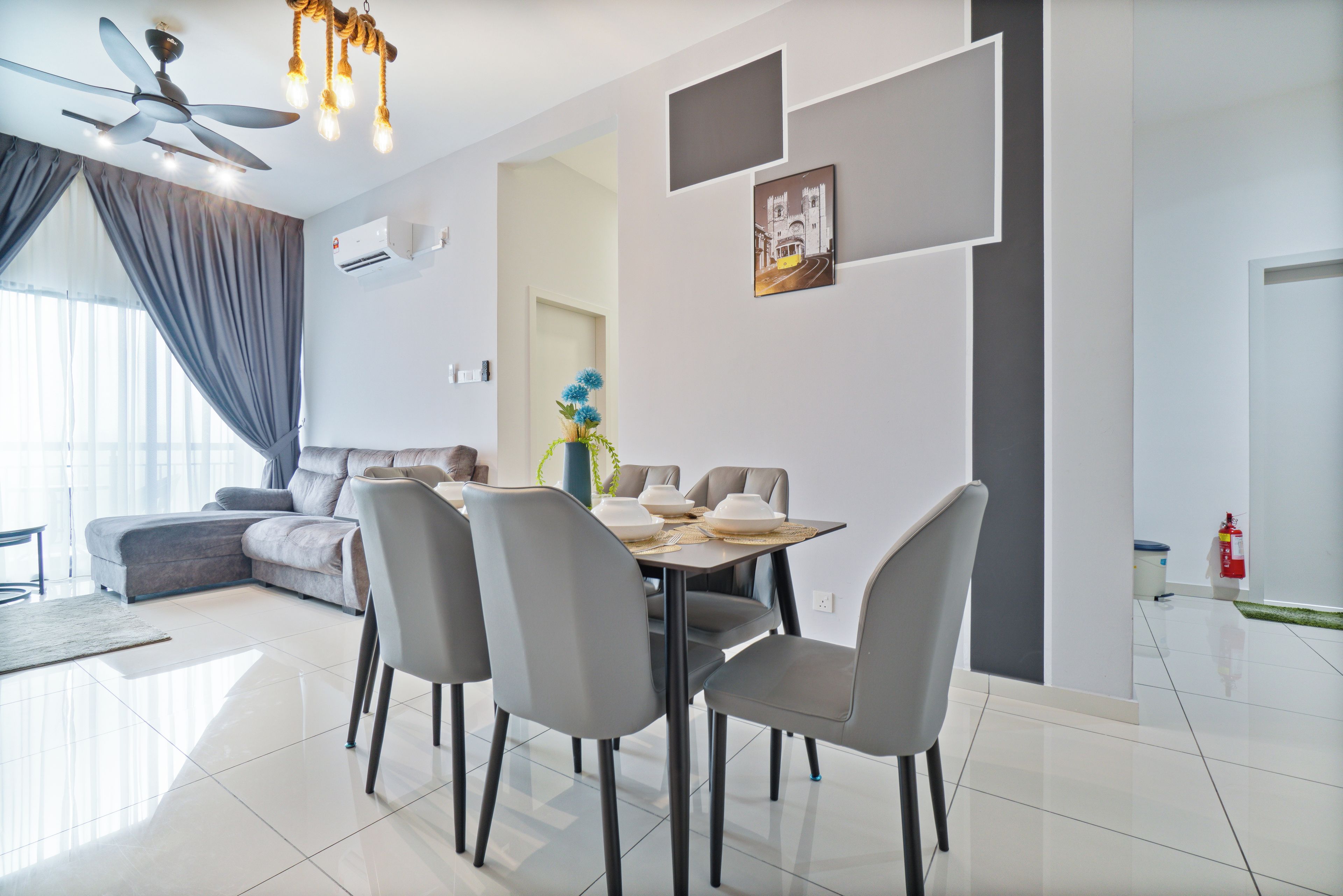 Een moderne woonkamer met een eethoek, een plafondventilator en een wandairconditioner.