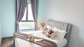 A bedroom with a bed, a ceiling fan, an air conditioning unit, and a window with curtains.