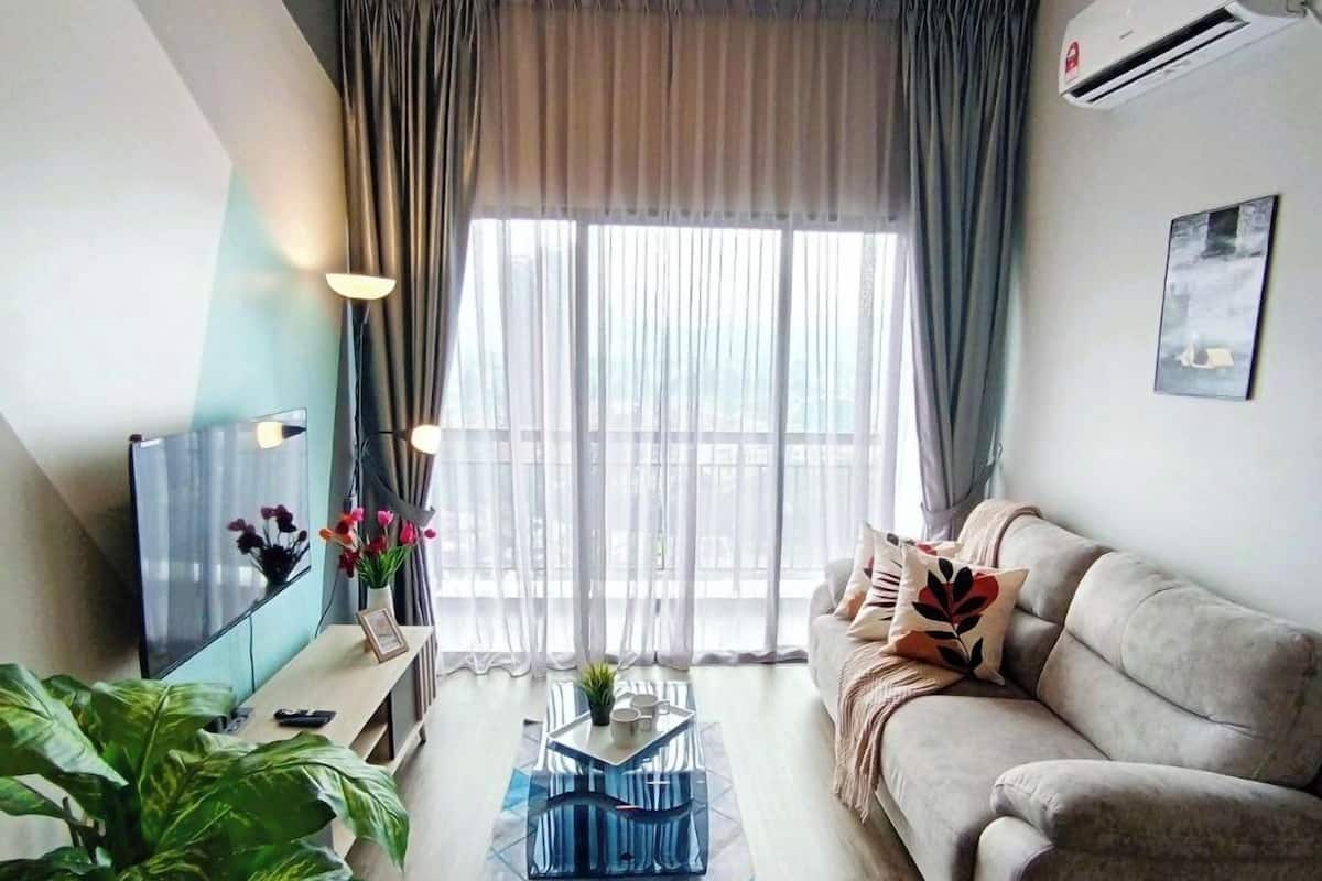 A living room with a ceiling fan, a sofa, a coffee table, a TV, and a large window with curtains.