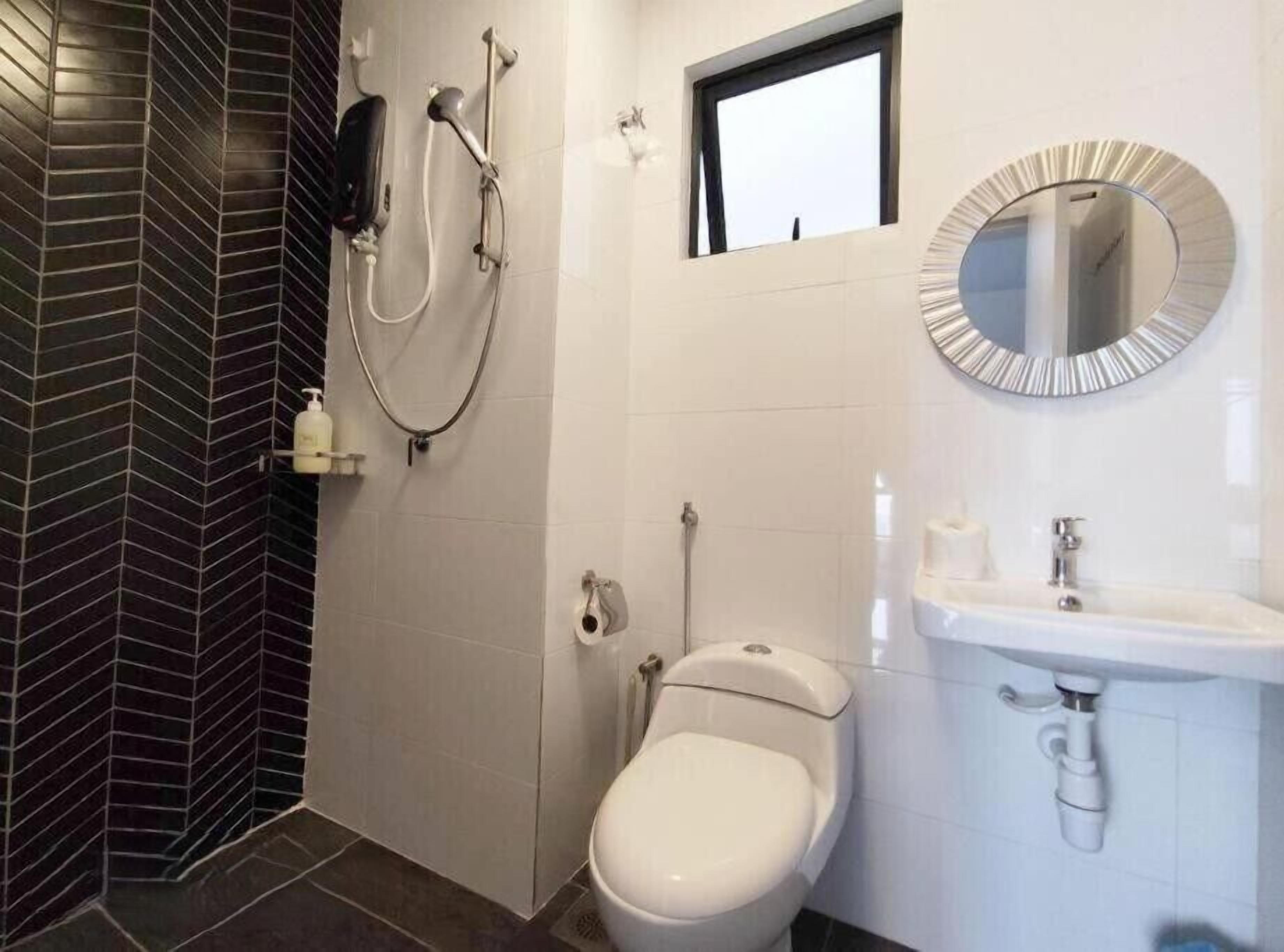A bathroom with a shower, toilet, and sink.