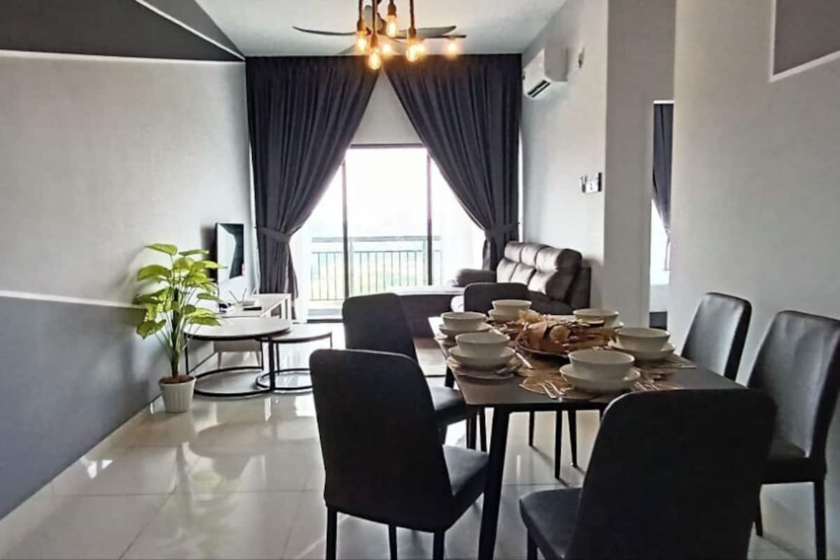 A modern dining area with a table set for six, a sofa, and a TV.