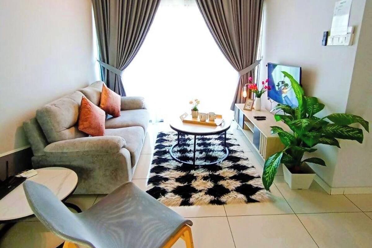A modern living room with a sofa, a round coffee table, a single chair, a ceiling fan, and a large window with curtains.