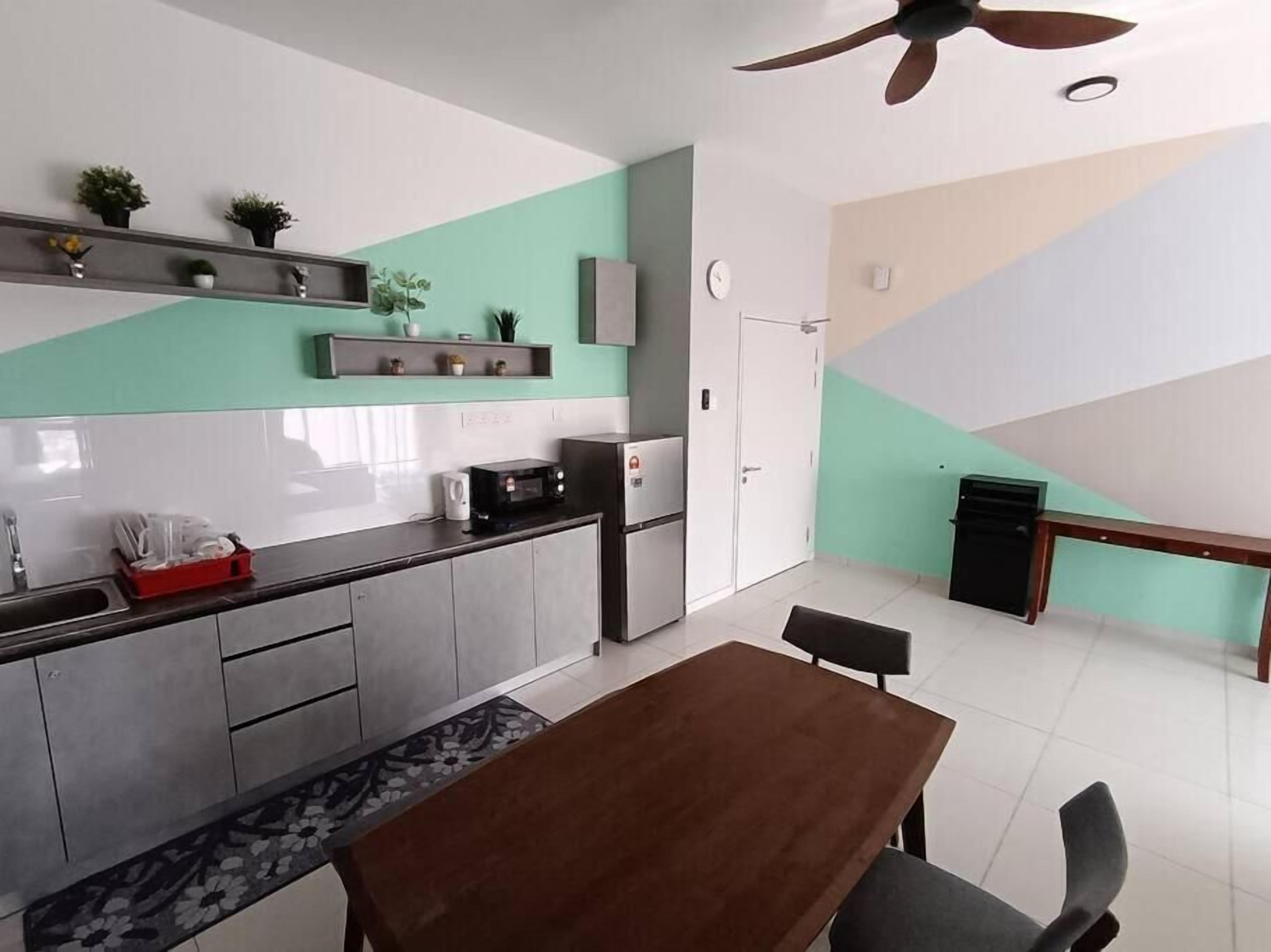 A modern kitchen with a dining area, featuring a wooden table and chairs, a microwave, and a refrigerator.