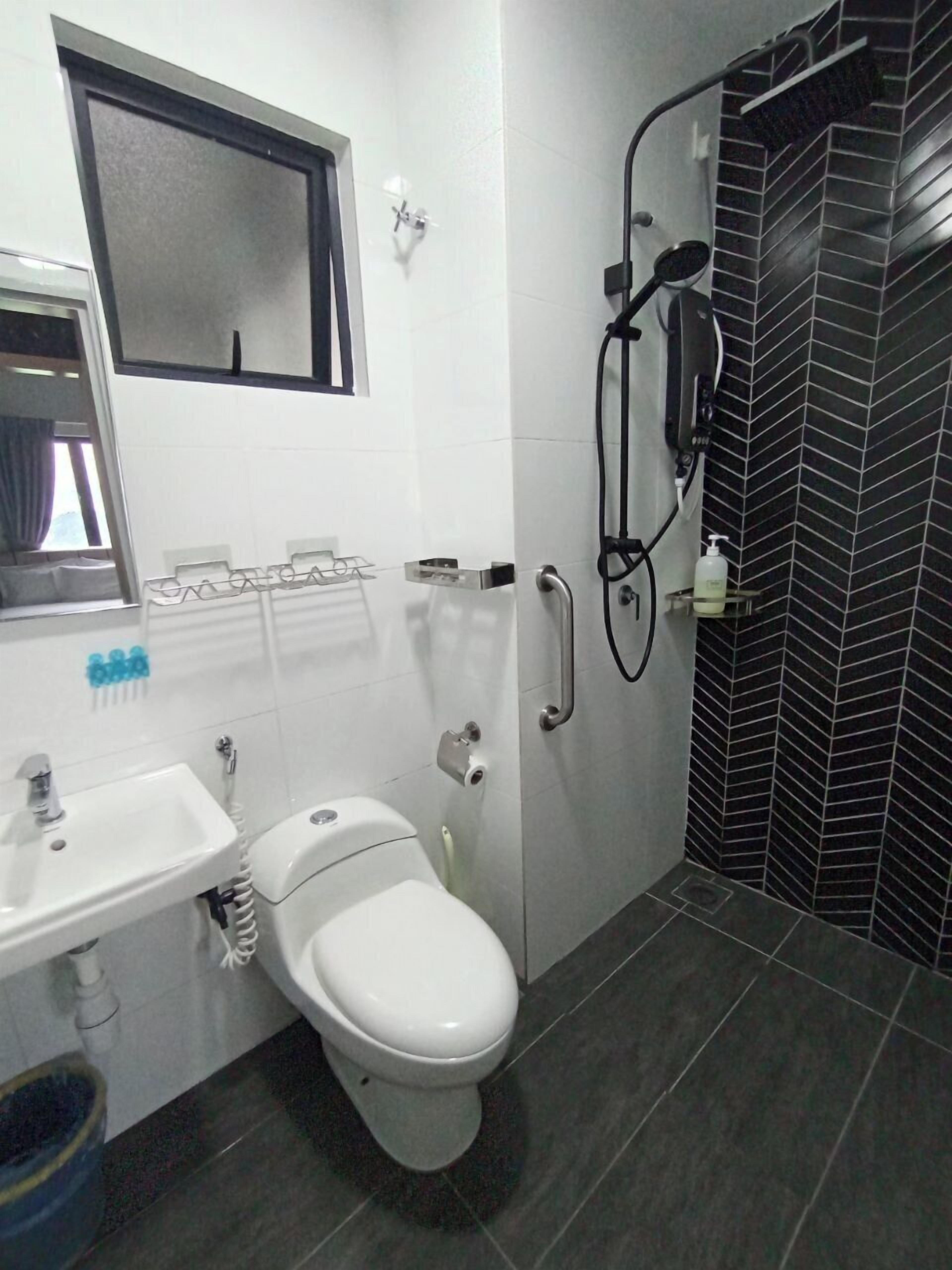Une salle de bain avec des toilettes, un lavabo et une douche.