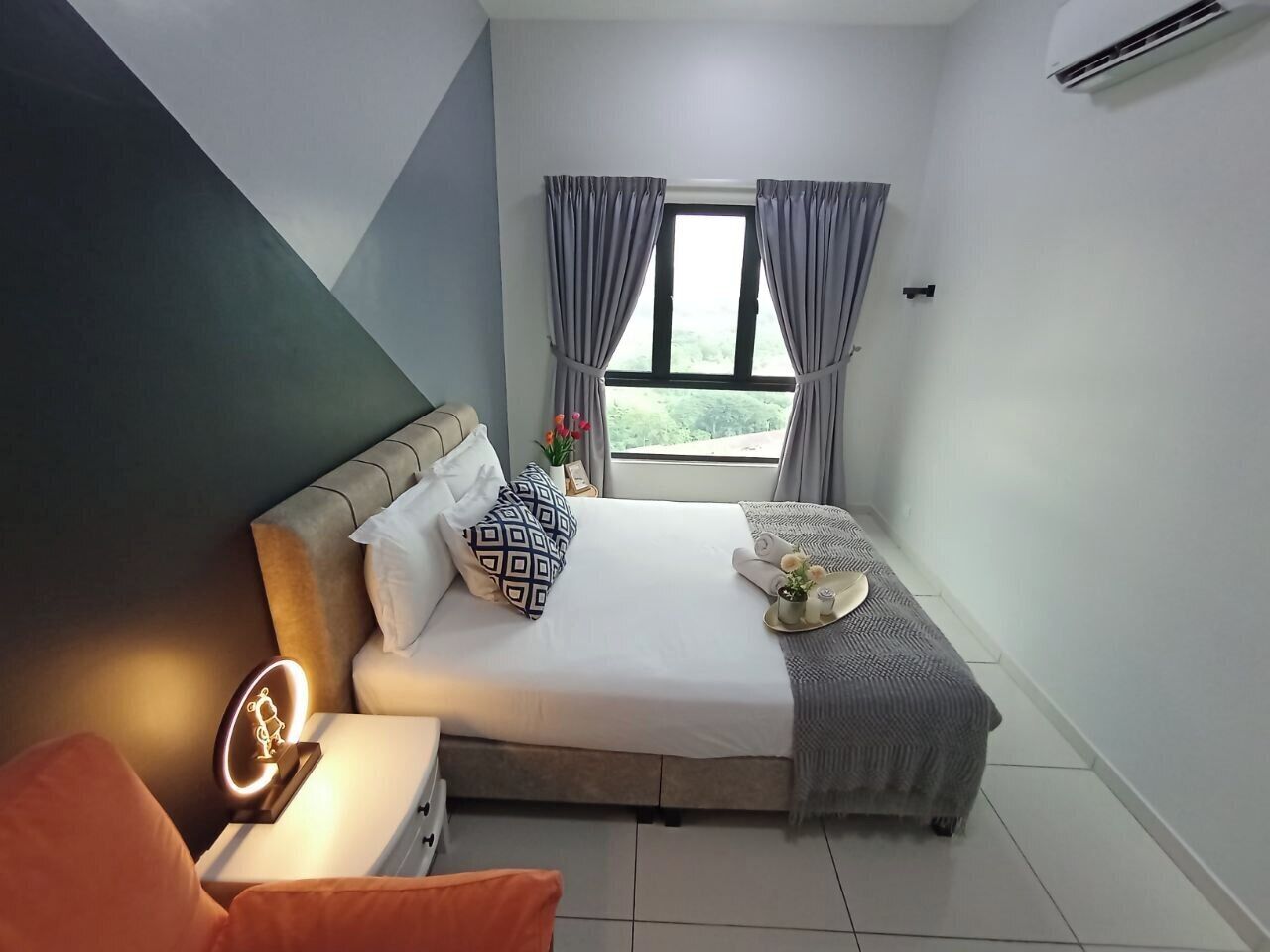 A neatly arranged bedroom with a bed, bedside table, and a nightstand.