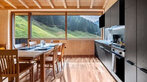 A modern kitchen with a large window overlooking a green landscape. - Apartment 'Rumwaldhof Enzian' with Mountain View, Shared Terrace and Wi-Fi (Sulden)