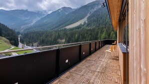 A balcony with a view of a valley and mountains, wooden flooring, and a railing. - Apartment 'Rumwaldhof Enzian' with Mountain View, Shared Terrace and Wi-Fi (Sulden)
