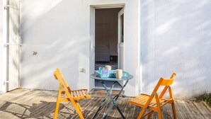 A small outdoor seating area with two wooden chairs and a table, a white wall, and a door leading inside. - Room with Private Bathroom near the Beaches of Oléron Island (Le Château-d'Oléron)