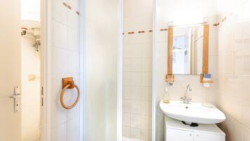 A bathroom with a shower, a sink, and a mirror.