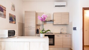 Une cuisine moderne avec des meubles en bois, un four à micro-ondes, un évier et une orchidée en pot.