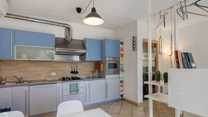 Eine moderne Küche mit blauen Schränken, Edelstahlgeräten und einem Essbereich in Weiß.