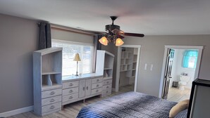 A bedroom with a bed, dresser, closet, and a ceiling fan. - Spacious 6-bedroom+ Studio Apartment with 12+ Guests-Dog friendly in Homer Hills (Homer)