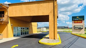 L’entrée d’un hôtel ValueStay, avec une enseigne bien visible, une allée couverte et un parking.