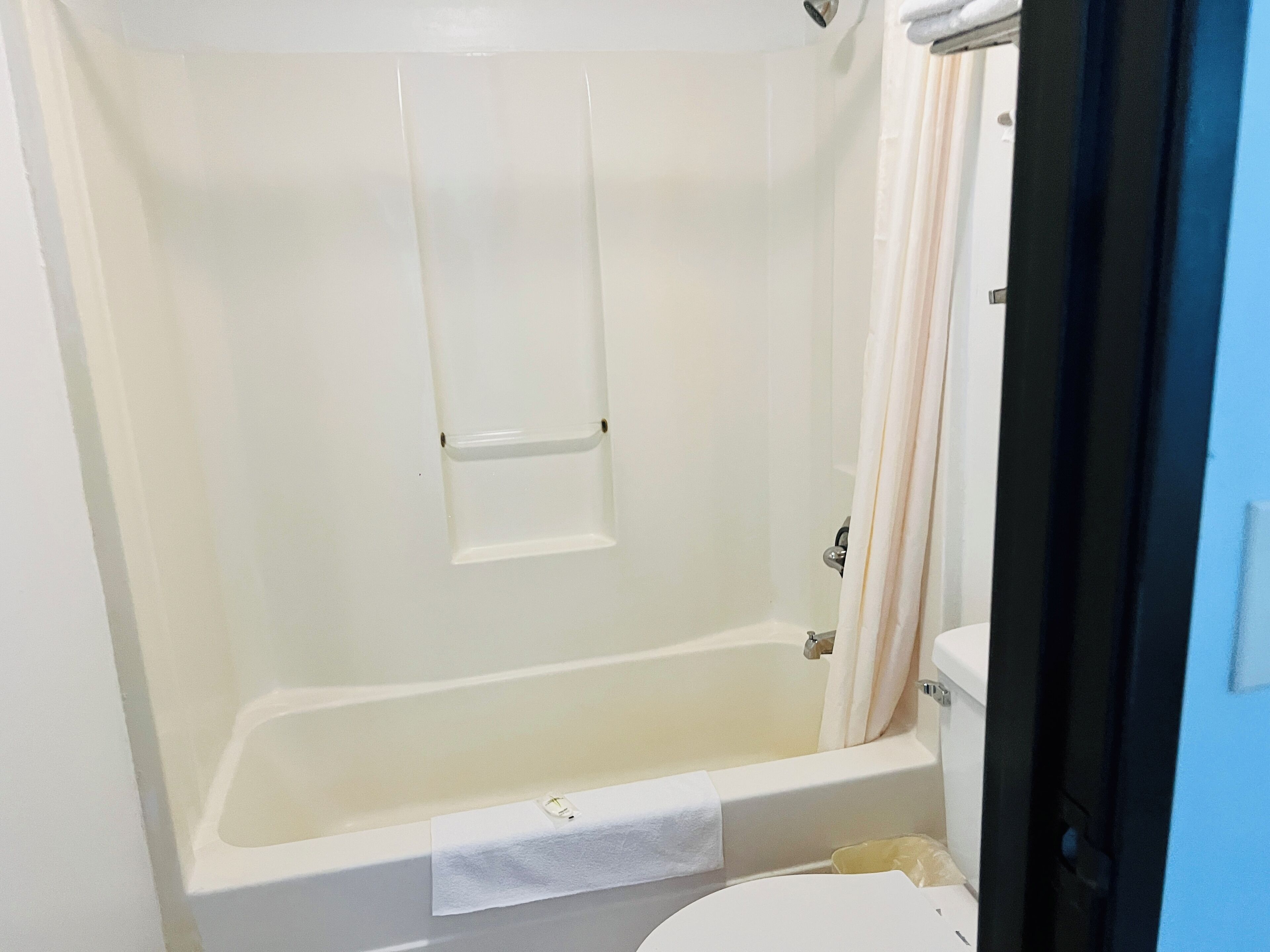 Un baño con bañera, inodoro y cortina de ducha.