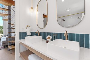 Une salle de bain avec deux lavabos, un miroir et un porte-serviettes.