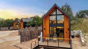 Ein modernes Hotel im Blockhausstil mit einer markanten Holzfassade, großen Fenstern und einer Terrassenfläche.
