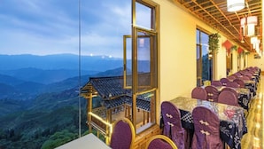 Un ristorante con terrazza che si affaccia su un paesaggio montuoso.