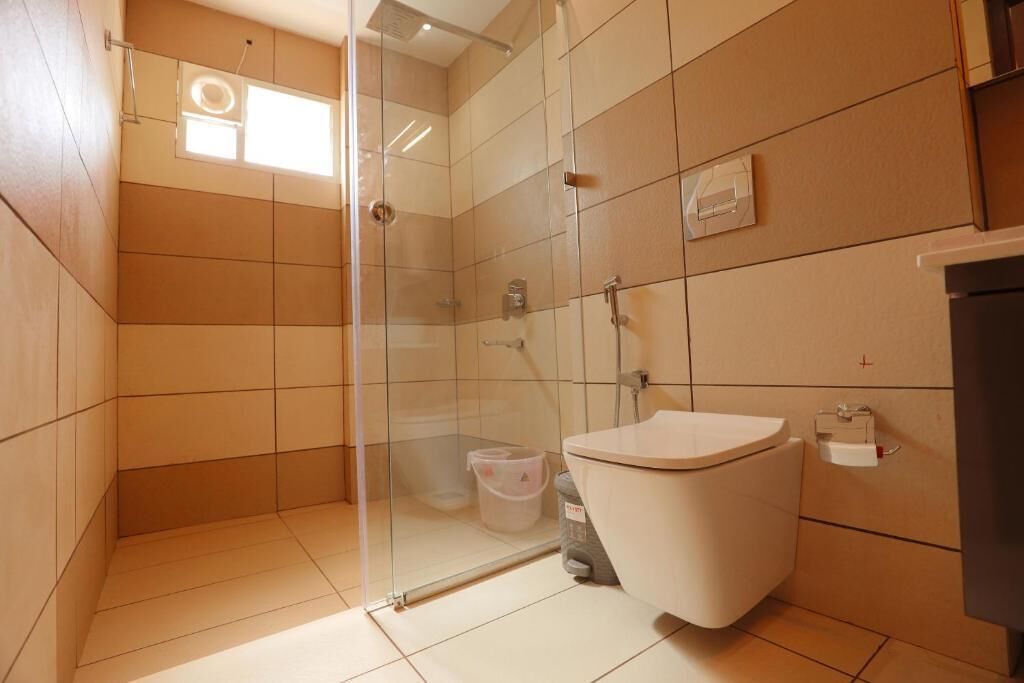 Un baño moderno con cabina de ducha de vidrio, inodoro y lavabo.