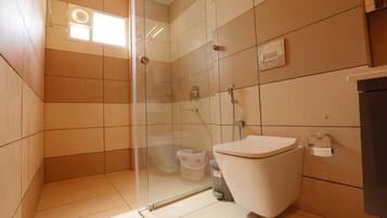 Un baño moderno con cabina de ducha de vidrio, inodoro y lavabo.