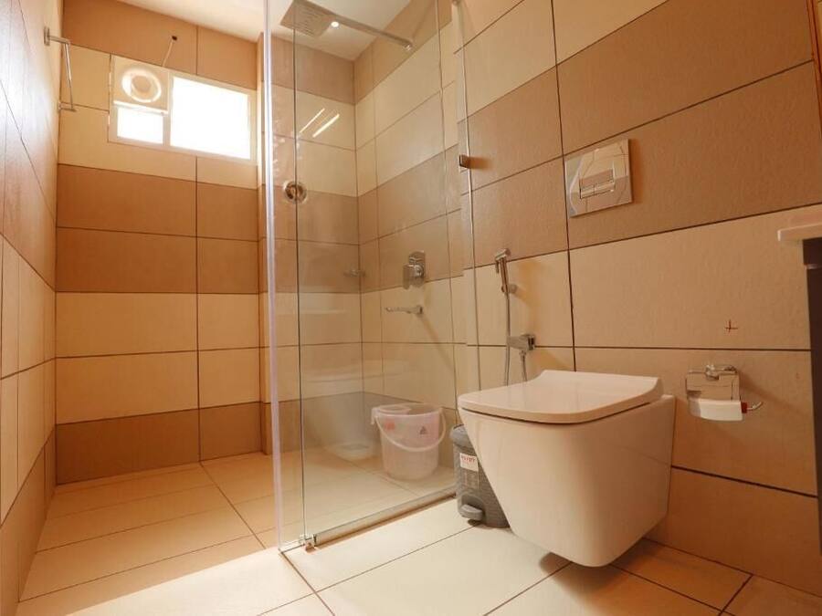 Un baño moderno con cabina de ducha de vidrio, inodoro y lavabo.