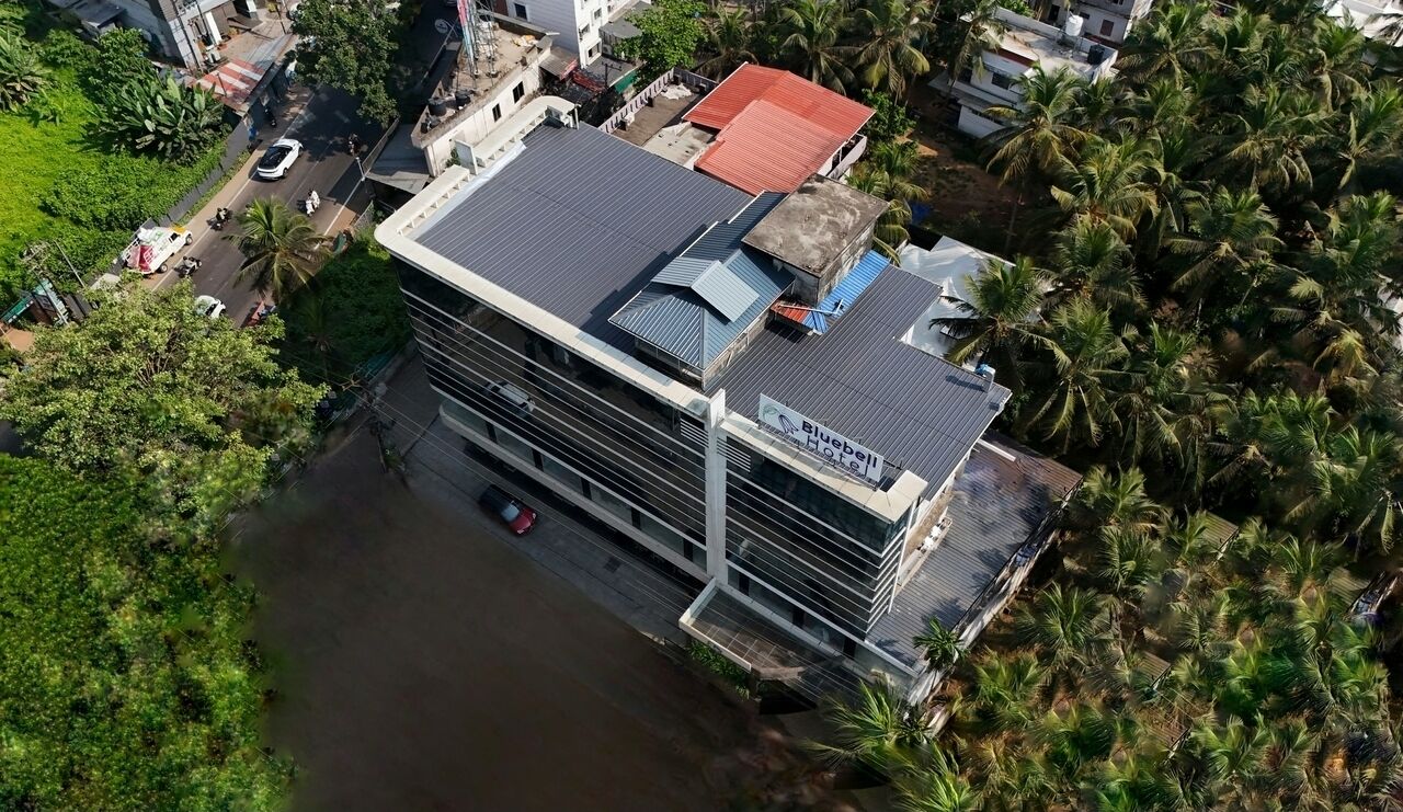 A hotel with a modern design, featuring a flat roof and a signboard.