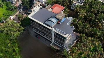 A hotel with a modern design, featuring a flat roof and a signboard.