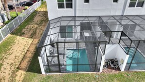 A glass-enclosed pool area with a clear view of the pool, surrounded by a white building with multiple windows. - Boutique Retreat, Azzure Resort, Near Orlando and Disney by Shine Villas (Davenport)