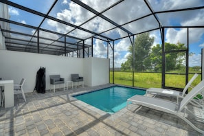 A covered outdoor swimming pool with a clear view of the sky and greenery outside. - Boutique Retreat, Azzure Resort, Near Orlando and Disney by Shine Villas (Davenport)